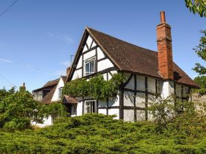 a white and black house with a chimney at Tudor Cottage in Bidford