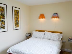 a bedroom with a bed and two lights on the wall at Brierdene End Cottage in Hartley