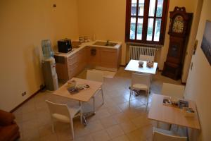 eine Küche mit Tischen und Stühlen und einer Uhr in der Unterkunft La Filanda B&B in Casorezzo