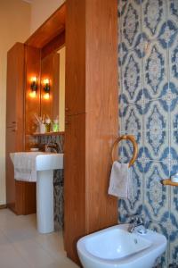 ein Badezimmer mit einem Waschbecken, einem WC und einem Spiegel in der Unterkunft La Filanda B&B in Casorezzo