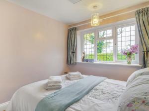 a bedroom with a bed and a window at Garden Cottage in Burgh