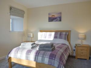 sypialnia z łóżkiem z ręcznikami w obiekcie Benwells Holiday Cottage w mieście Maud