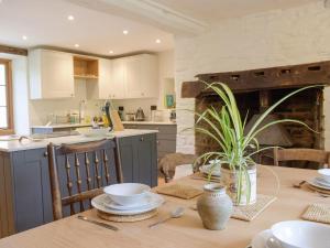 a kitchen with a wooden table with a dining room at Lower Goytre Farmhouse in Llanvair Waterdine
