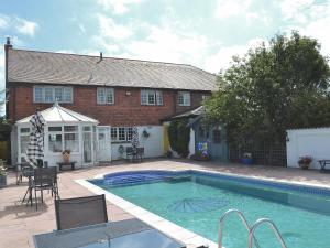 a house with a swimming pool in front of a house at Cockle Warren in South Hayling