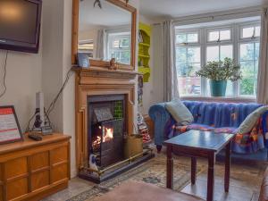 a living room with a fireplace and a couch at The Old Post Office in Aston Cantlow