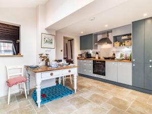 a kitchen with a table and a counter top at Riverside Cottage in Bungay