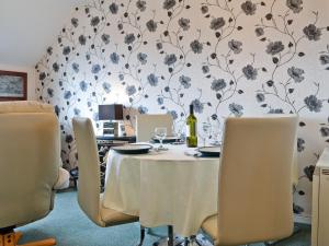 a dining room with a table with a bottle of wine at Rainbows End in Bowness-on-Windermere