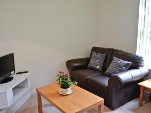 Bluebell - 28864 في Stokeinteignhead: غرفة معيشة مع أريكة جلدية وطاولة قهوة