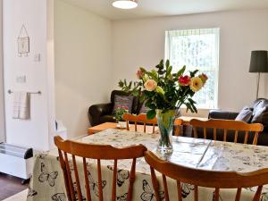 - une table à manger avec un vase de fleurs dans l'établissement Bluebell - 28864, à Stokeinteignhead