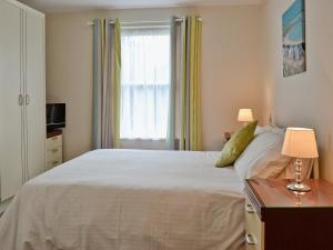 StokeinteignheadにあるBluebell - 28864のベッドルーム(大きな白いベッド1台、窓付)