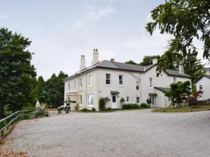 una gran casa blanca con una entrada de grava en Bluebell - 28864 en Stokeinteignhead