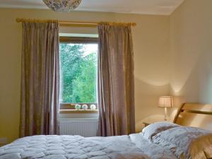a bedroom with a bed and a window at Glen View in Buchanty
