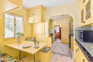 a kitchen with yellow walls and a table in a room at The Spanish Palace in Los Angeles