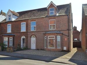 a red brick house with a white door at Filey House in Sheringham