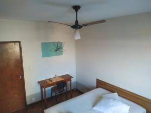 a bedroom with a bed and a table with a ceiling fan at Libero Hotel - By Up Hotel in São João da Boa Vista