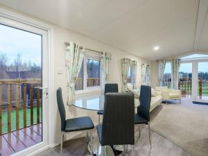 a dining room with a table and chairs and a couch at The Paddocks - Uk7112 in Dollar