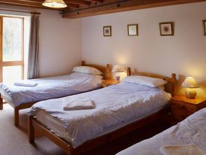 1 dormitorio con 2 camas, 2 lámparas y una ventana en The Granary, en Somersal Herbert