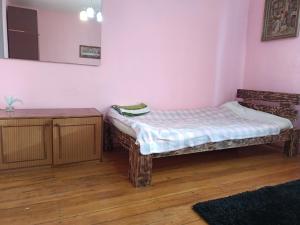 a small room with a bed and a wooden floor at Krone Hostel in Uzhhorod