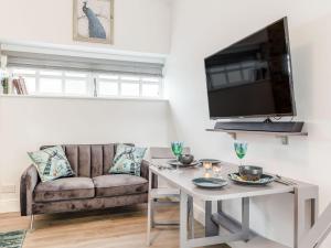 a living room with a couch and a table at Peacock On The Pin in Stisted