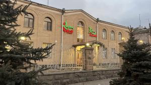 基洛瓦坎的住宿－Argishti Hotel，一座大砖砌建筑,上面有两面旗帜