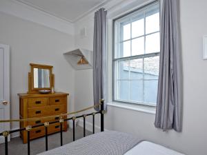 a bedroom with a window and a bed and a dresser at Courts View in Newton Abbot