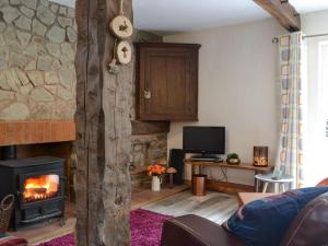 a living room with a fireplace and a stone wall at Fourwinds in Farlow