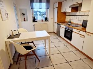 アシャッフェンブルクにあるHofgarten Apartmentsの小さなキッチン(白いテーブル、椅子付)