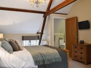 1 dormitorio con cama y lámpara de araña en Red Lion Lodge en Myddle