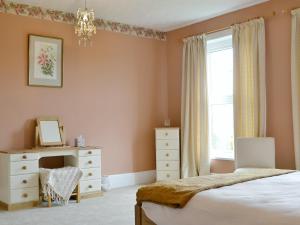 a bedroom with a bed and a dresser and a window at Forda Farm in Black Torrington