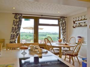 Woodend Bungalow في Hucknall under Huthwaite: مطبخ وغرفة طعام مع طاولة وكراسي