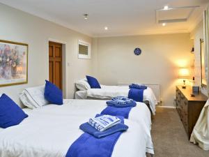 Dos camas en una habitación con toallas azules. en Woodend Bungalow, en Hucknall under Huthwaite
