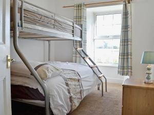 a bedroom with a bunk bed and a window at Ford Farmhouse in Carew