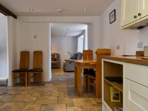 a kitchen and living room with a table and chairs at Glimsters Cottage in Kentisbeare