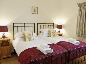 2 Betten mit Handtüchern darüber in einem Schlafzimmer in der Unterkunft Oak Tree Cottage in Gillamoor