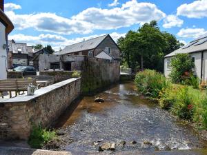 a small river in a town with houses at Glimsters Cottage in Kentisbeare