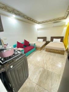 een woonkamer met 2 bedden en een fornuis bij Zafero beach FAMILIES ONLY in Alexandrië
