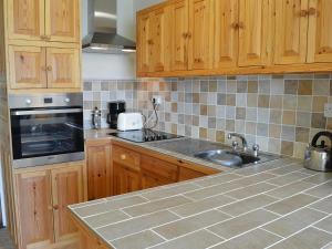 a kitchen with wooden cabinets and a sink at Lowenna - Ukc3538 in Mevagissey