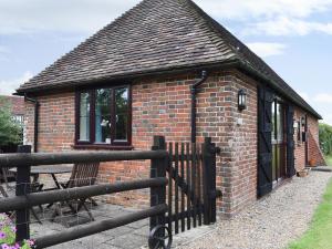 a brick building with a fence in front of it at The Smithy in Crundale