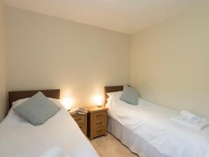 a bedroom with two beds and a night stand with lights at Property 2 in Wroxall