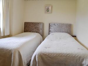 two beds sitting next to each other in a bedroom at Swaledale Cottag in Caldbeck