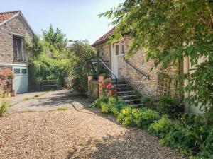 a stone house with a staircase leading up to a building at Garden Flat in Pilton