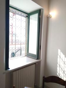 uma janela com uma moldura verde e um radiador num quarto em TakeAmalfiCoast Minori Center em Minori