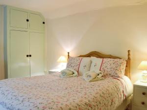 a bedroom with a bed with two towels on it at Yew Tree Cottage in Arford