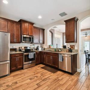 a kitchen with wooden cabinets and stainless steel appliances at 2 King Bed Hot Tub Home in Tampa
