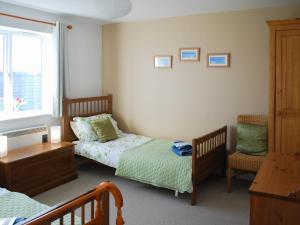シーハウシズにあるErskine Cottageのベッドルーム1室(ベッド2台、デスク、椅子付)