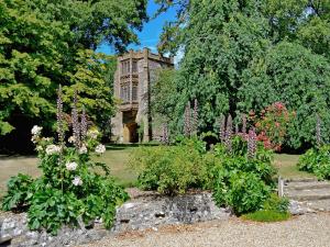 a garden with flowers in front of a building at Cerne Abbey Cottage in Cerne Abbas