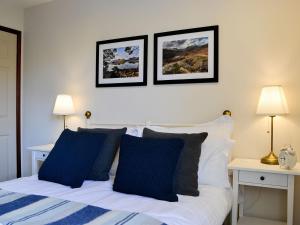um quarto com uma cama com duas fotografias na parede em Melbreak em Lorton