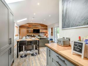 an open kitchen and living room with a table and chairs at Appletree Lodge in Minishant