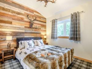 een slaapkamer met een bed met een houten muur bij Appletree Lodge in Minishant