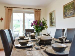 une table à manger avec des chaises et une grande fenêtre dans l'établissement Oak Tree Cottage - E5062, à Lydbrook